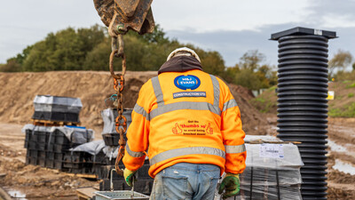 M&J Evans Construction banksman moving a MuckStopper with an excavator