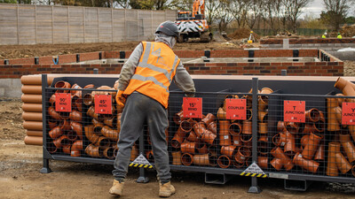 Construction worker fetching a drainage fitting from a SiteStak workstation